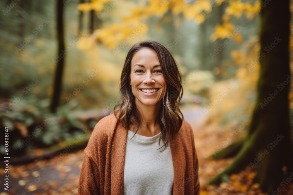 Portrait of smiling woman standing in autumn forest and looking at camera Portrait of smiling woman standing in autumn forest and looking at camera