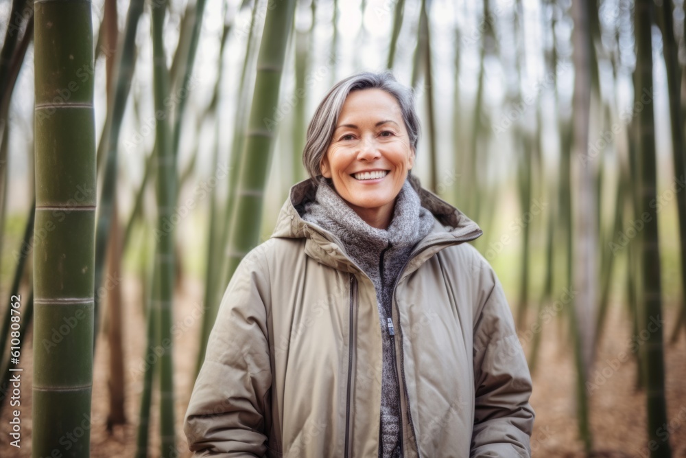 Portrait of a smiling senior woman standing in bamboo forest on a sunny day