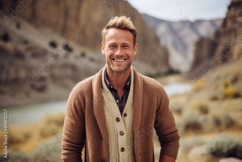 Handsome young man smiling at camera while standing in a canyon
