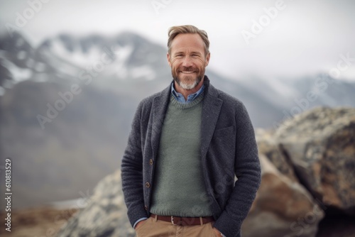 Portrait of a handsome mature man standing on top of a mountain © Leon Waltz