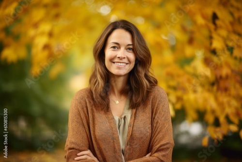 Portrait of a smiling young woman in an autumnal park.