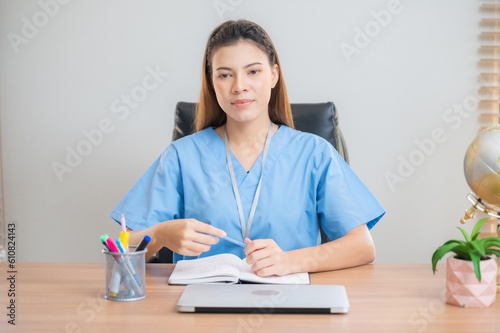 Asian nurse sitting in office. © Suriyo