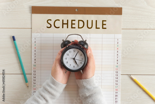Girl’s hands holding clock on the calendar. Schedules, Plans, Reservations, Appointments, etc. カレンダーの上で時計を持つ女の子の手。予定、スケジュール、計画、予約など
