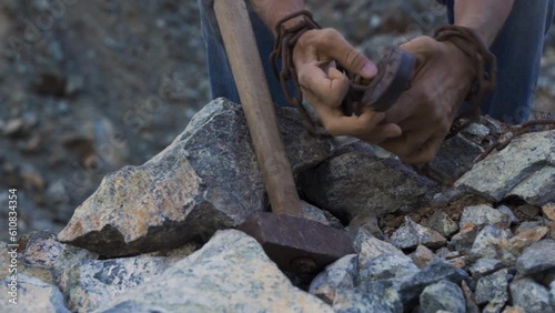 Slave hard work. Hard labor. The convict's hands are holding a hammer. Desire to be free. Desire to break the shackles