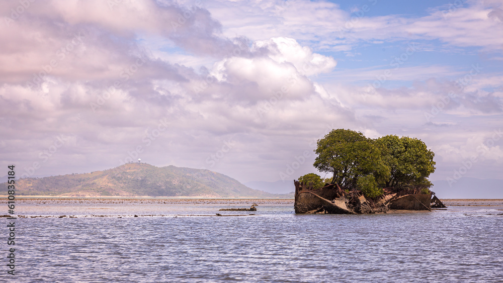 shipwreck and a large body of water with a mountain in the background on magnetic island