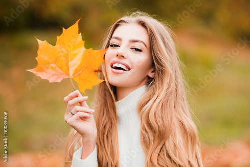 Happy smiling woman holding in her hands yellow maple leaves over autumn background. Autumn dream. Woman dreams in autumn fall. Beauty girl dream. Daydreamer woman. Dreams and imagination.