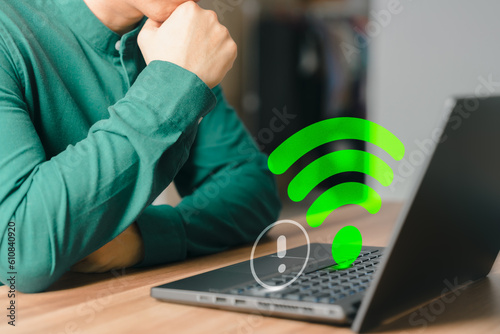 Adult man using a computer laptop to connect to wifi in his home but wifi not working, and waiting to load digital game data from the website, concept technology of waiting to connect to wifi.