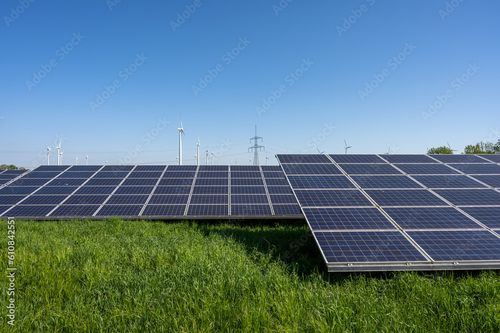 Solar plant with power lines and wind turbines in the back seen in Germany Solar plant with power lines and wind turbines in the back seen in Germany