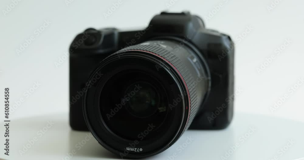 Black photo camera with lens rotating on white background closeup. Choosing professional camera Black photo camera with lens rotating on white background closeup. Choosing professional camera