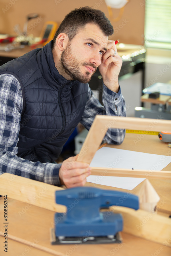 handsome carpenter planning work in his workshop handsome carpenter planning work in his workshop