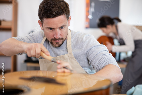 luthier craftsman adjusting a classic guitar