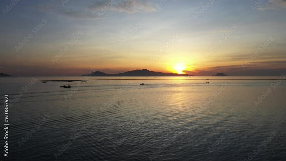 Fishermen throwing fishing net during dawn with boats at the sea gate. Concept Fisherman's life style. Cua Dai, Hoi An, Asia, Vietnam.