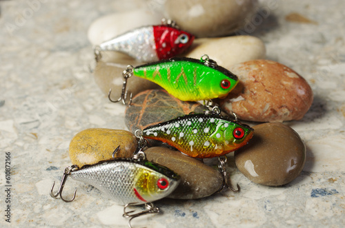 Four solid spinning lures on a background of sea stones.