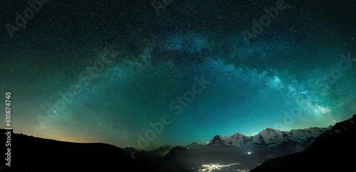 Milky Way arc and stars in night sky over the Swiss Alps with the famous alpen peaks Eiger, Monch and Jungfrau down right in the background