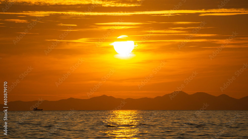 Vibrant orange sunset in the sea, in Ao Nang, Thailand.