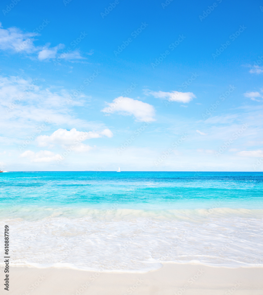 Tropical white sand beach and blue sky at summer sunny day.  Idyllic tropical beach scene. 