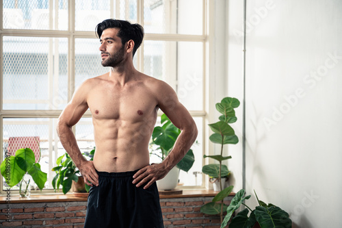 Portrait photo of young smart Middle East man athlete with naked unshirt squeezing body muscle during exercise training alone at home. photo