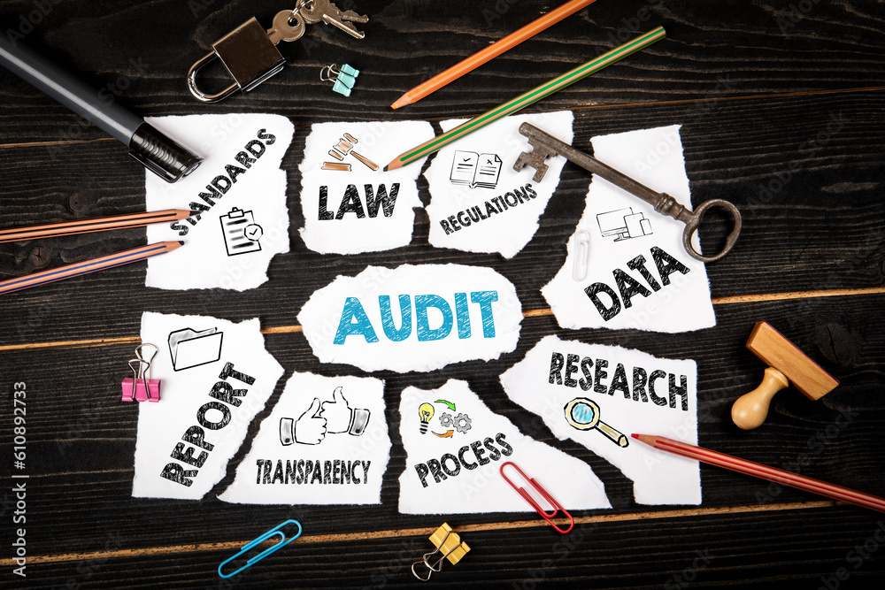 Audit concept. Torn sheet of paper with text and icons and dark wooden ...