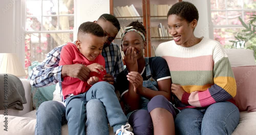 Portrait of happy african american parents, son and daughter sitting on sofa in house, slow motion Portrait of happy african american parents, son and daughter sitting on sofa in house, slow motion