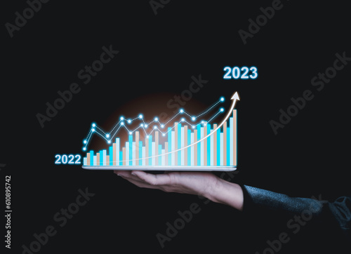 Businessman or showing a growing virtual hologram on dark tone background,planning and strategy, Business growth, progress or success concept. 