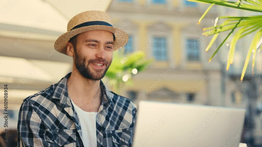 Hispanic Freelancer Engaged in Online Video Call at City Cafe, Utilizing Laptop. Businessman Working Outdoors with Urban Street Background, Demonstrating Professional Communication. Hispanic Freelancer Engaged in Online Video Call at City Cafe, Utilizing Laptop. Businessman Working Outdoors with Urban Street Background, Demonstrating Professional Communication.