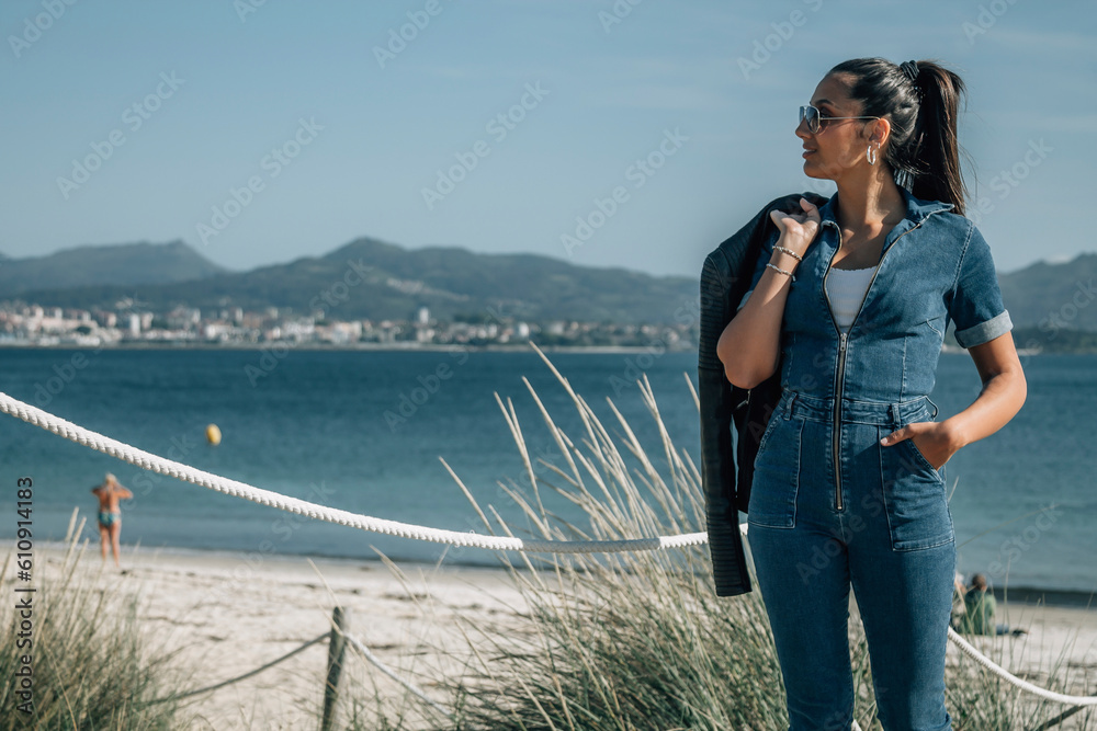 hispanic latin woman walking on the wooden boardwalk of the beach