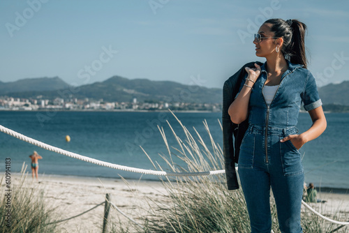 hispanic latin woman walking on the wooden boardwalk of the beach