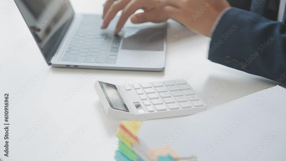 Close up Business woman using calculator and laptop for do math finance on wooden desk, tax, accounting, statistics and analytical research concept Close up Business woman using calculator and laptop for do math finance on wooden desk, tax, accounting, statistics and analytical research concept