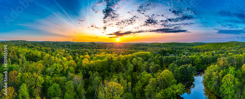 Airiel landscape flying over wilderness and stream into the sunrise sunset. 