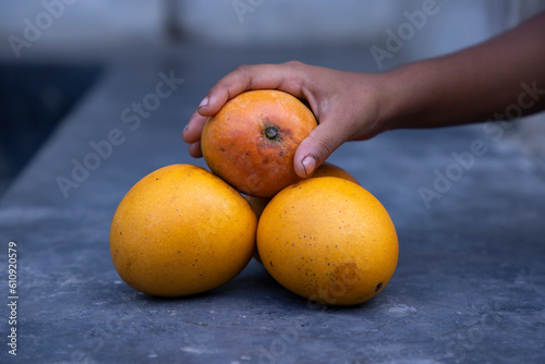 Mango fruit in hand on the table. Selective focus