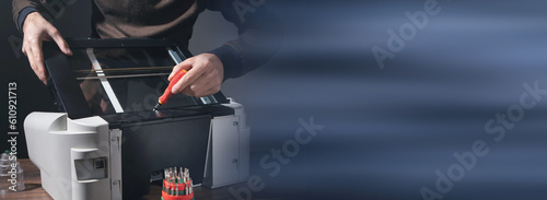 Caucasian man repairing digital printer.