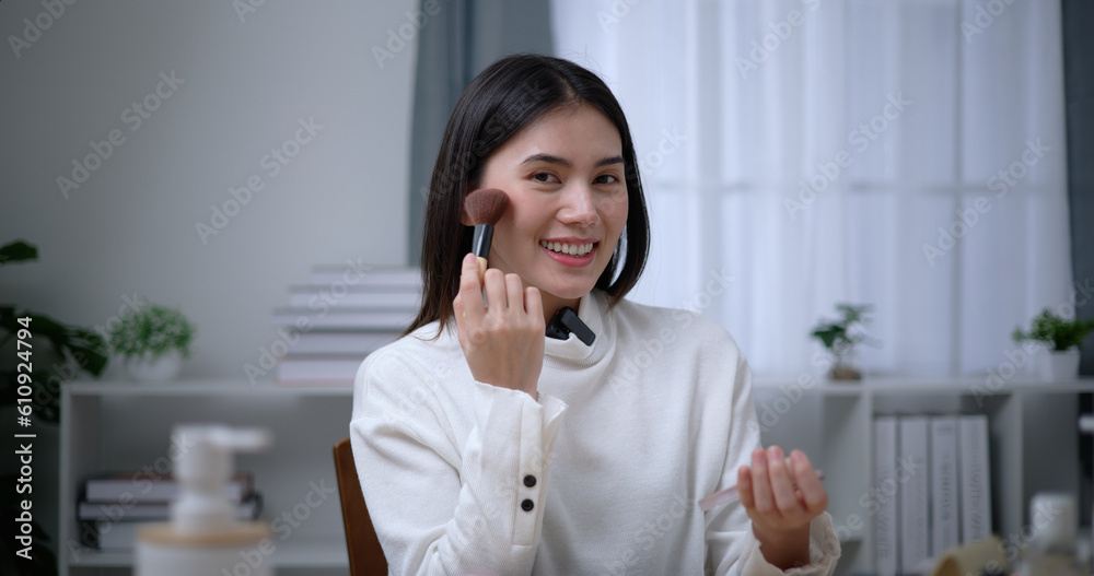 Beautiful young Asian woman blogger shows how to make up and use cosmetics Beautiful young Asian woman blogger shows how to make up and use cosmetics