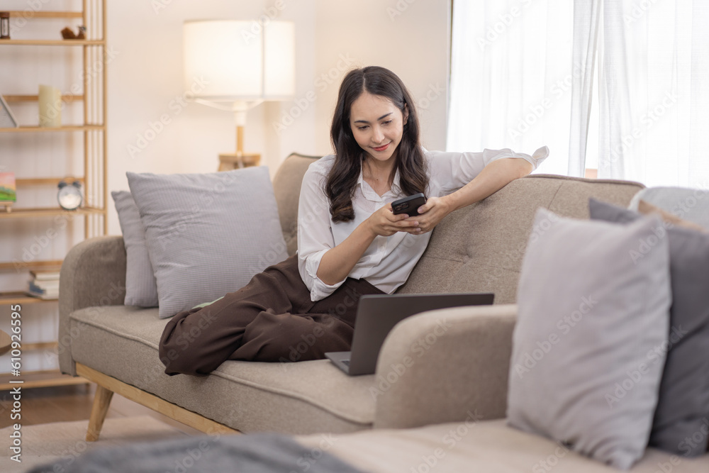 Portrait of a young happy asian female freelancer sitting on the couch and working on project, watching movie on phone laptop, studying, blogging, resting and chatting online. Portrait of a young happy asian female freelancer sitting on the couch and working on project, watching movie on phone laptop, studying, blogging, resting and chatting online.