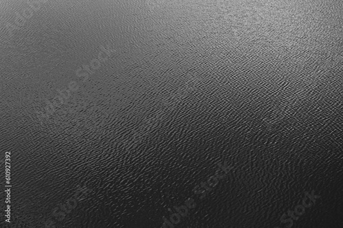 Black water surface with waves. Water ripples. Texture of the water surface.