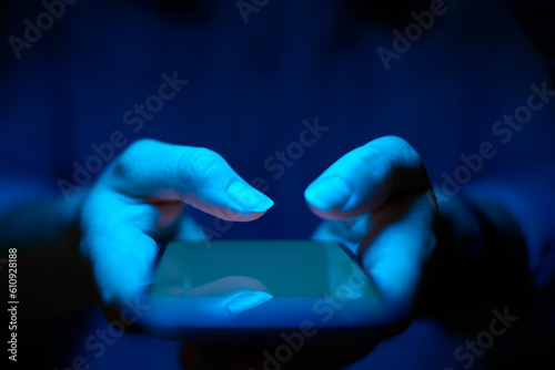 Close Up Of Woman Using Mobile Phone With Blue Lighting Effect