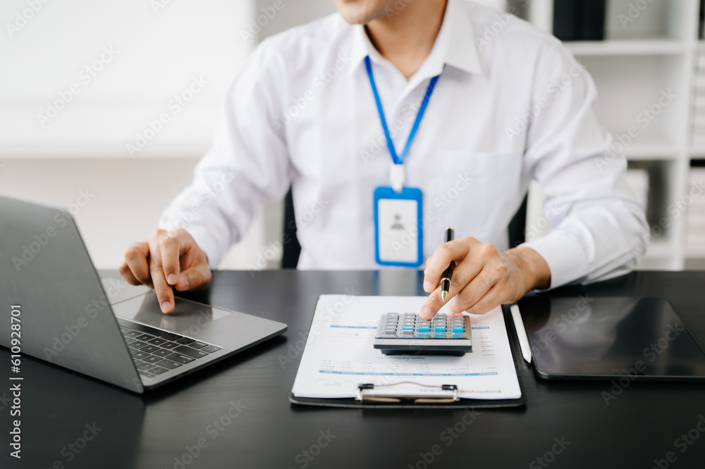 Men counting coins on calculator taking from the piggy bank. hand holding pen working on calculator to calculate on desk about cost at office. Men counting coins on calculator taking from the piggy bank. hand holding pen working on calculator to calculate on desk about cost at office.