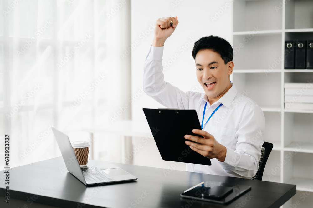 Asian business man are delighted and happy with the work they do on their tablet, laptop and taking notes at the office.. Asian business man are delighted and happy with the work they do on their tablet, laptop and taking notes at the office..
