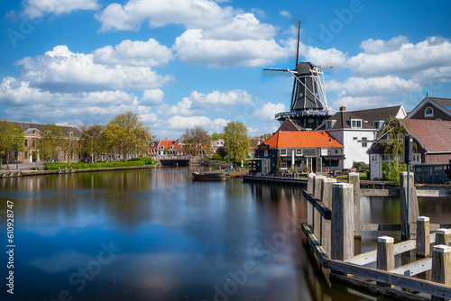 Colorful Romantic View of Harlem Cityscape with Landmark Windmill De Adriaan on Spaarne River at Daytime in Harlem, Netherlands