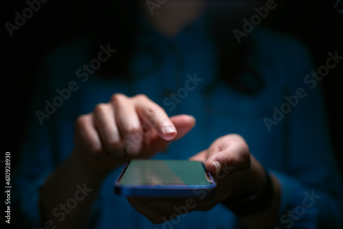 Close Up Of Woman Using Mobile Phone With Finger Poised Above Screen