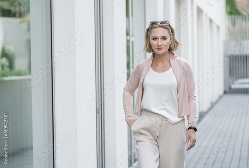 Portrait of Happy Beautiful White Caucasian Adult Woman She is Wearing Active Lifestyle Outdoor Sportwear. White t-shirt. Vilnius, Lithuania.