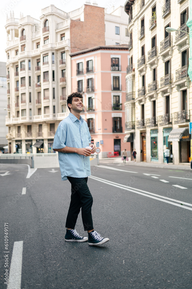 Young man crossing the road in the city