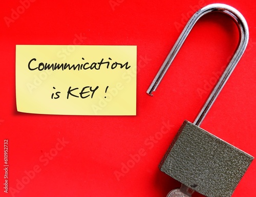 Lock pad, stick note on red background with handwritten text COMMUNICATION IS KEY, means communication is key to good relationship and leadership, to explain what are experiencing and what really need photo