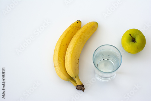 Banana, apple and glass of water isolated on white background