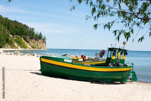 Green fishing boat on the shore.