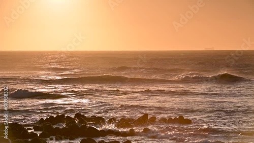 Orange sea waves and sky with clouds. Dramatic landscape by the sea at dusk. The Fugui Cape Lighthouse in Shimen. Taiwan photo