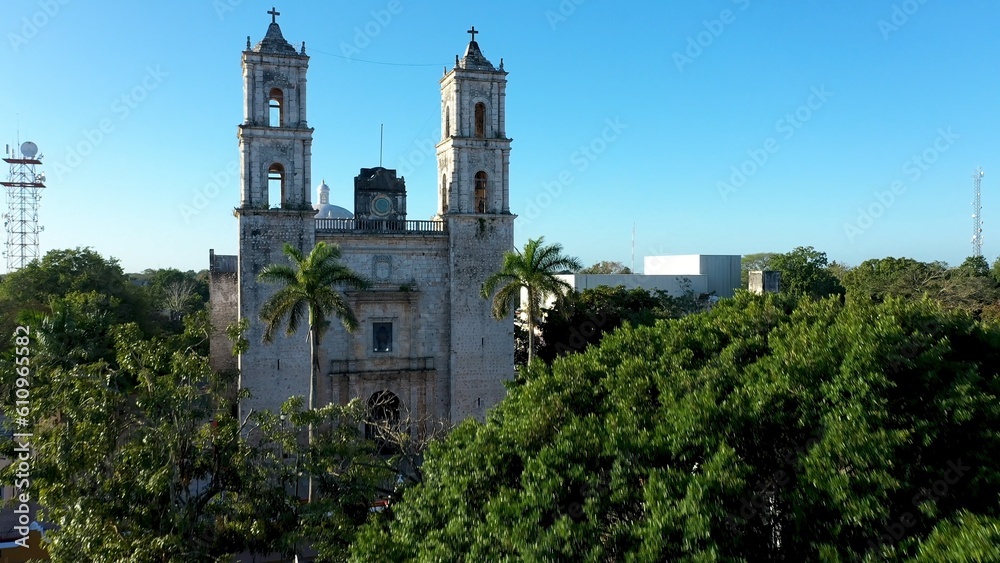 Early morning aerial view over park fountain above trees and over the Cathedral de San Gervasio in Valladolid, Yucatan, Mexico.