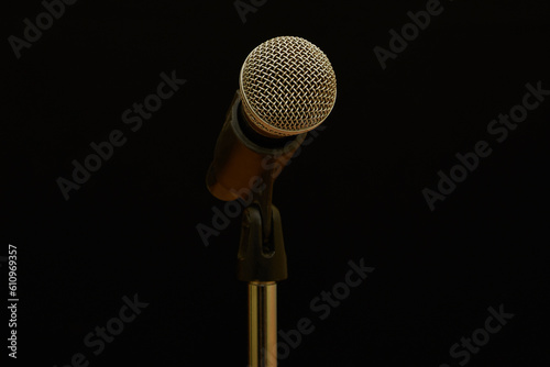 Dynamic vocal microphone on a stand on a black background in close-up