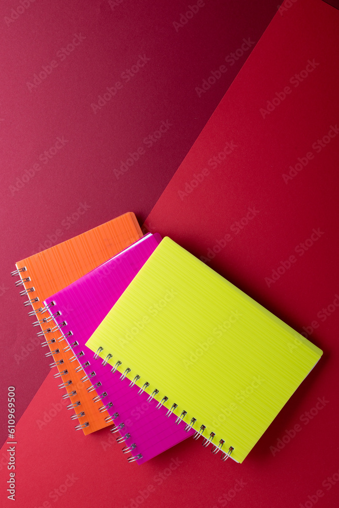 Three notebooks with binding and copy space on red background Three notebooks with binding and copy space on red background