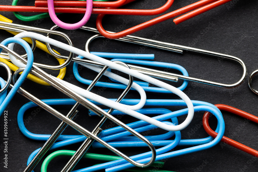 Close up of close up of multi coloured paper clips on black background Close up of close up of multi coloured paper clips on black background