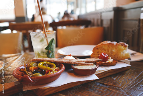A selection of best appetizers of Portugal food or portuguese tapas - smoked ham, peppers, a variety of cheese, crackers, liver pate and several traditional kinds of jam
